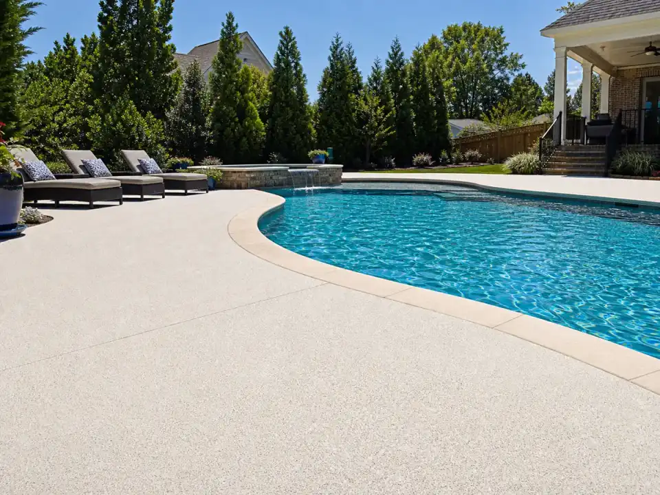 Light textured pool deck coating around a blue pool